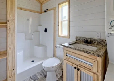Frontier model home bathroom with a granite-top vanity, toilet and shower.
