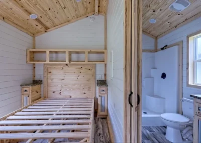 Frontier model home bedroom with a platform bed and attached bathroom.