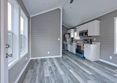 Savanna model home kitchen equipped with white cabinets and stainless steel appliances.