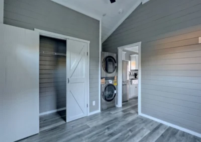 A Savanna model home room with washer-dryer. The kitchen is visible partially.